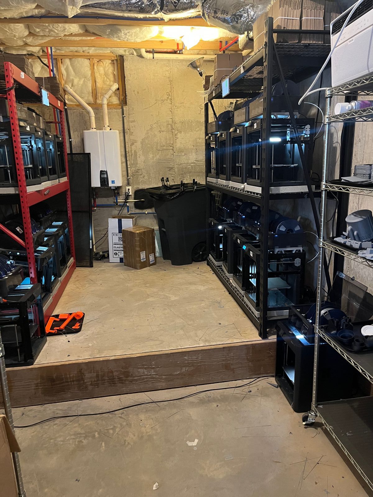 From the basement - the original print farm: insulation, a water heater, and printers crammed onto a couple of racks.