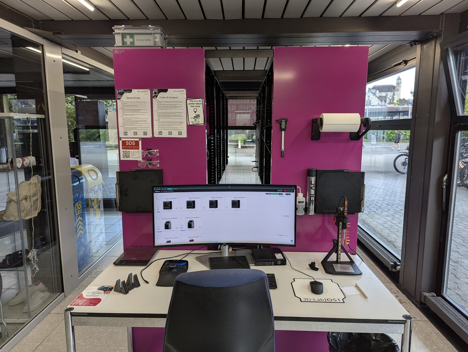 The SimplyPrint dashboard on an ultrawide monitor at the OST 3D-Lab operator desk, showing printer status cards