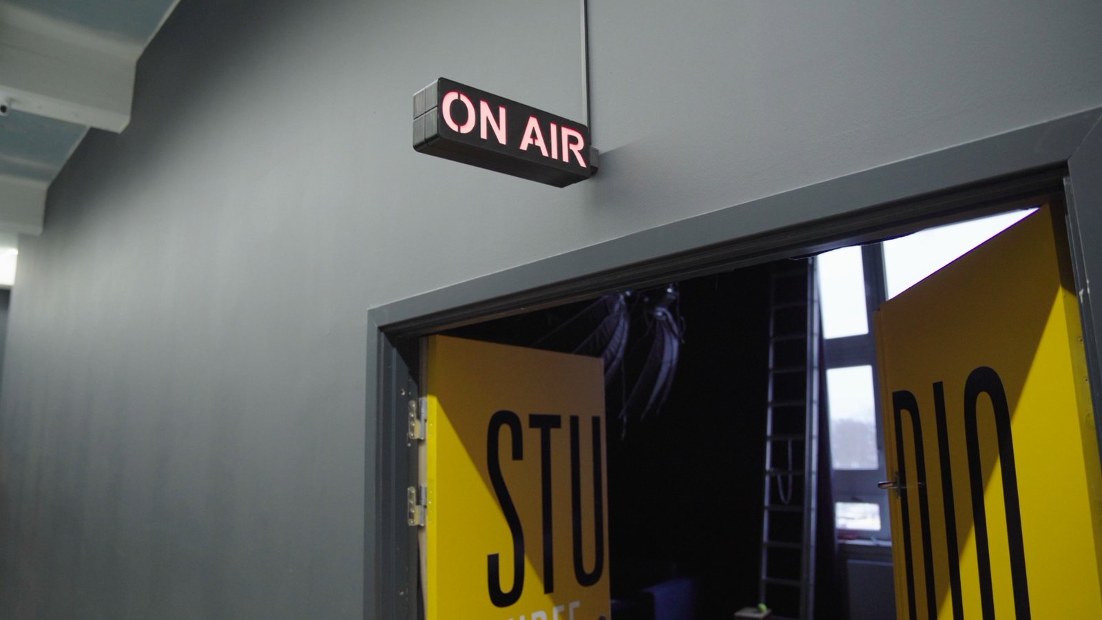 A 3D-printed ON AIR light box glowing red above the open door to SpeakerBee's studio with yellow STUDIO lettering