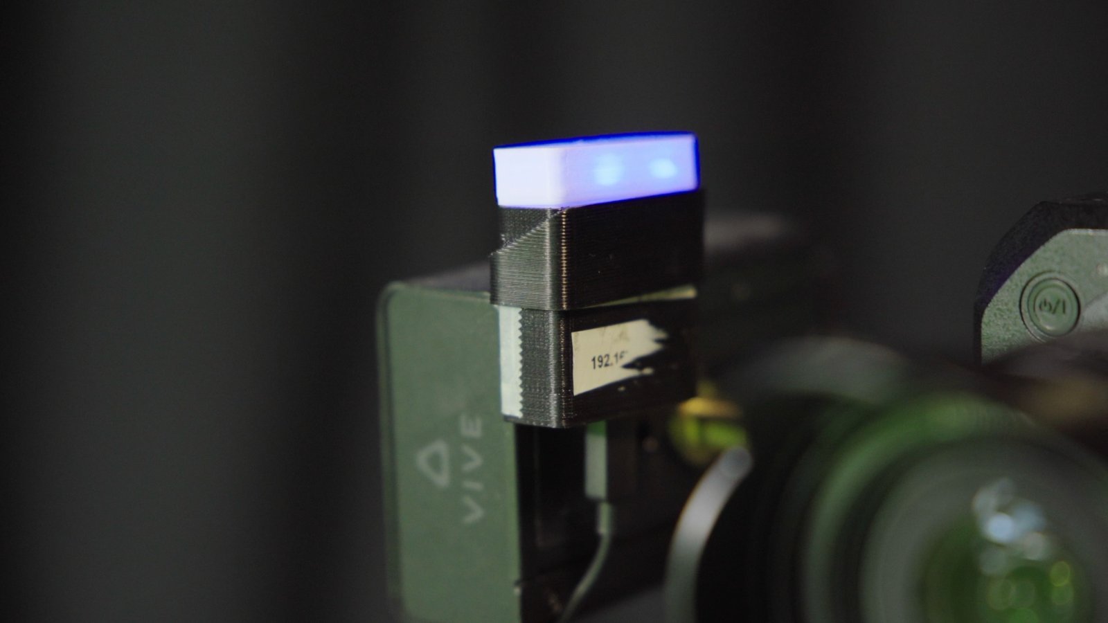 A 3D-printed on-air tally light mounted on a broadcast camera in SpeakerBee's studio, glowing to show the camera is live