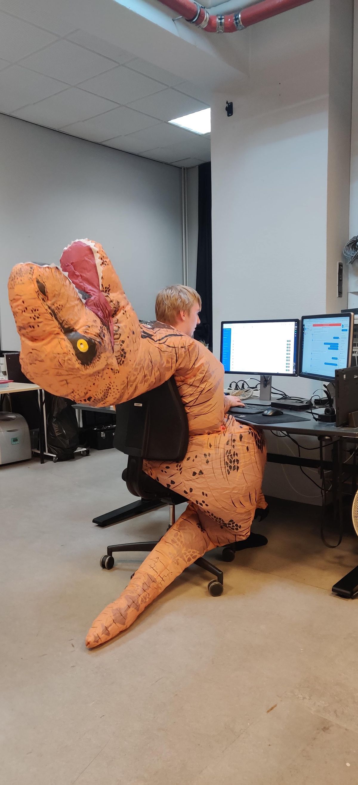 Albert in a T-Rex suit at his desk